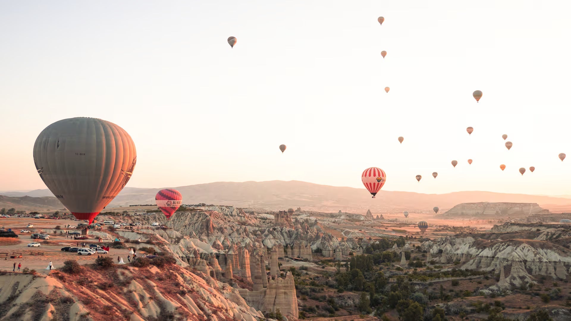 Fine art photography of hot air balloons drifting over the fairy chimneys of Cappadocia, Turkey, by Venturer Studios.